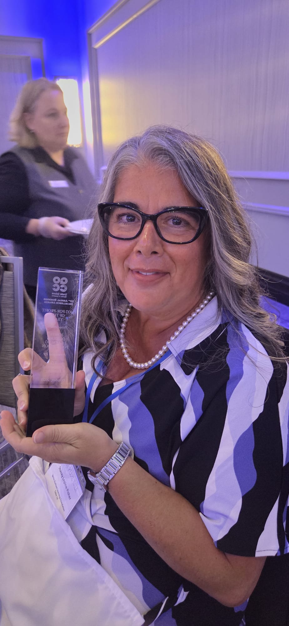 Stacey Lepine-Fisher holding a Not-For-Profit of the Year award at the Greater Oshawa Chamber of Commerce Business Excellence Awards.